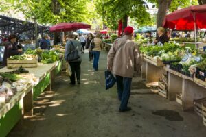 Farmers market with people walking around the stalls.