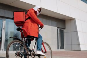 Man on bike delivering food for company.