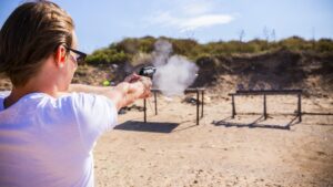 Woman firing a pistol at targets on a shooting range.