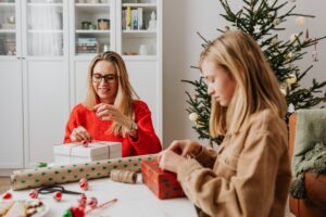Mom with daughter wrapping gifts after learning small business ideas for kids.
