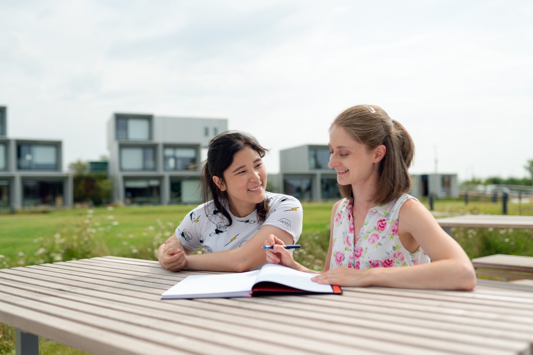 A woman tutoring another younger woman, one of many business ideas for young adults.