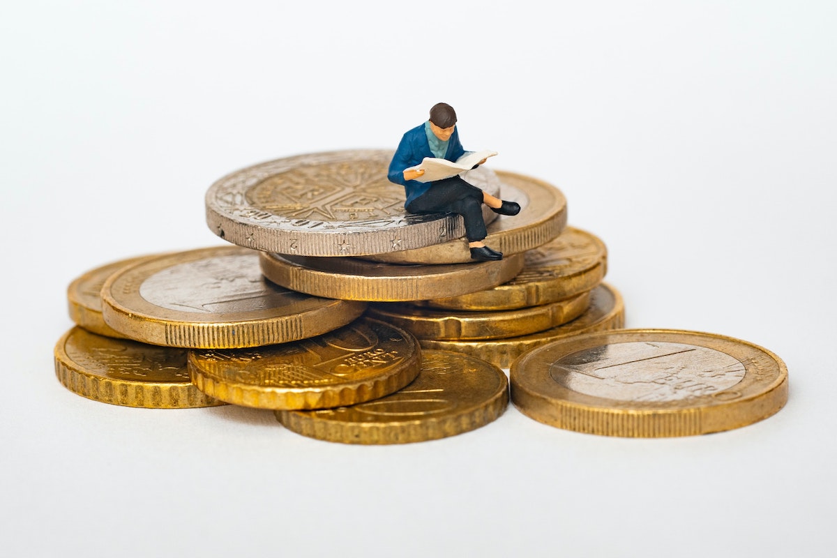 Toy man sitting on a pile of cash