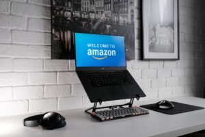 Picture of a laptop computer on a stand with welcome to Amazon on the screen.
