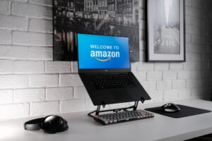 画面上のAmazonへようこそとスタンド上のラップトップコンピュータの写真。