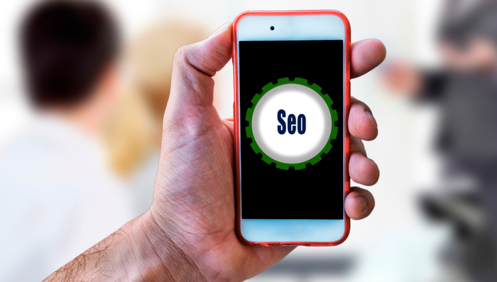 a hand holding a mobile phone with a picture of a cog that says seo