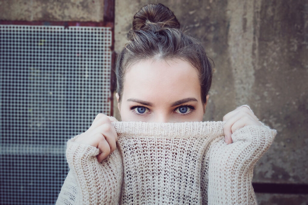 Woman with sweater over nose - smelly Cider clothing