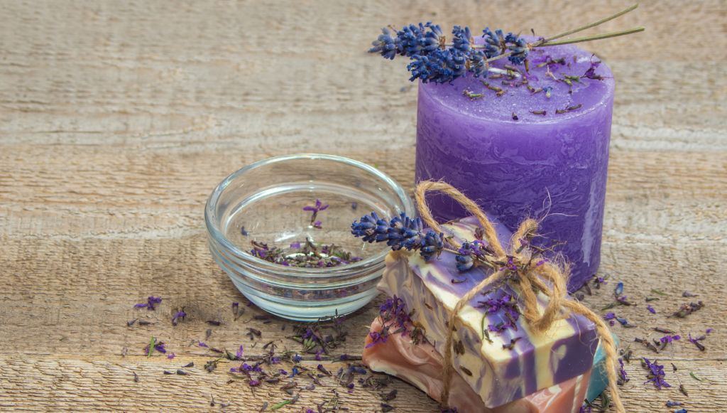 Candle Company Name Ideas - a purple pillar candle and a stack of soaps with lavender scattered around 