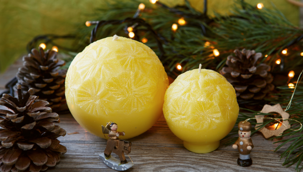 Candle Company Name Ideas - two handmade candles in the shape of a ball against a backdrop of a christmas tree