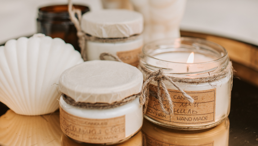 Candle Company Name Ideas - jar candles arranged on a reflective tray with some shells