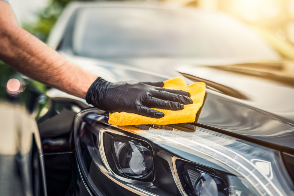 How To Start A Car Detailing Business - someone cleaning the exterior of a car with a microfibre cloth