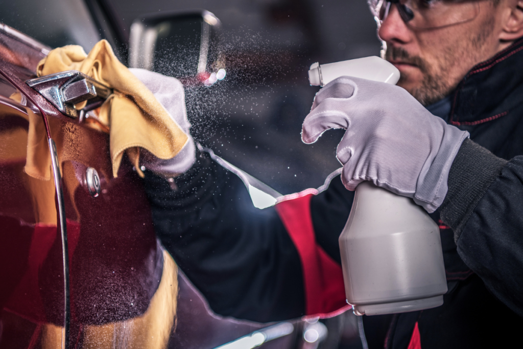 How To Start A Car Detailing Business - an image of a man holding a spray bottle and cleaning a car door handle