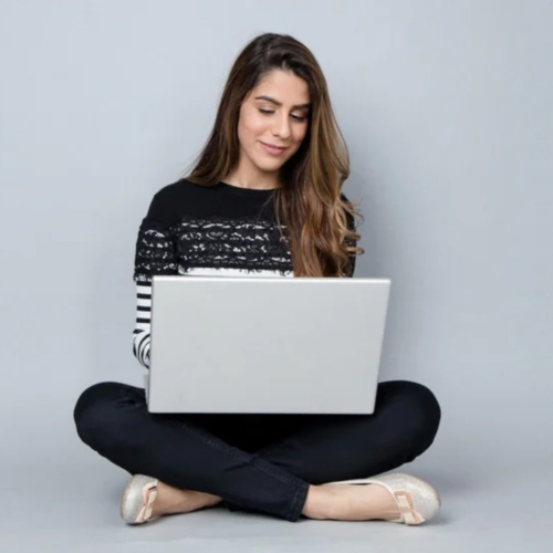 Woman sitting on the floor using a computer