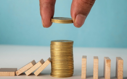 a stack of coins between wooden square blocks that are falling