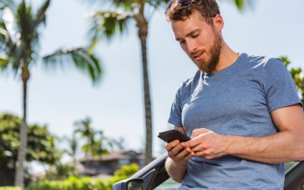 A man on his cell phone in a tropical area